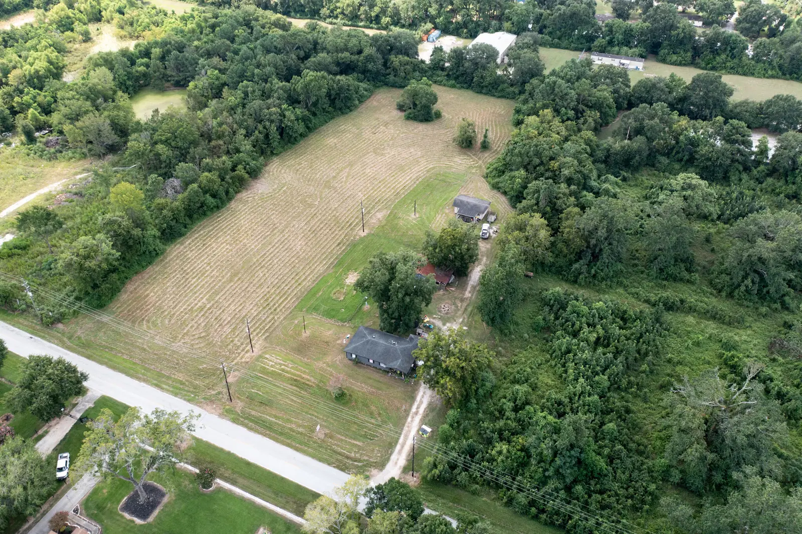 Aerial view of the mostly cleared 5-acre tract with the existing house and outbuilding on the eastern side