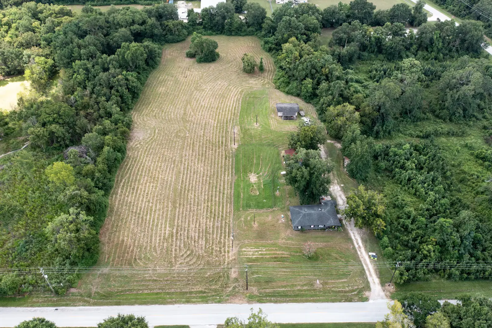 Wider aerial of the Tomball industrial tract and the surrounding tree line and neighbouring parcels